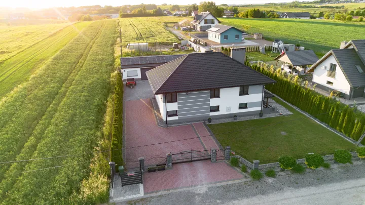 Widok z drona: dom wśród pól, podjazd z kostki