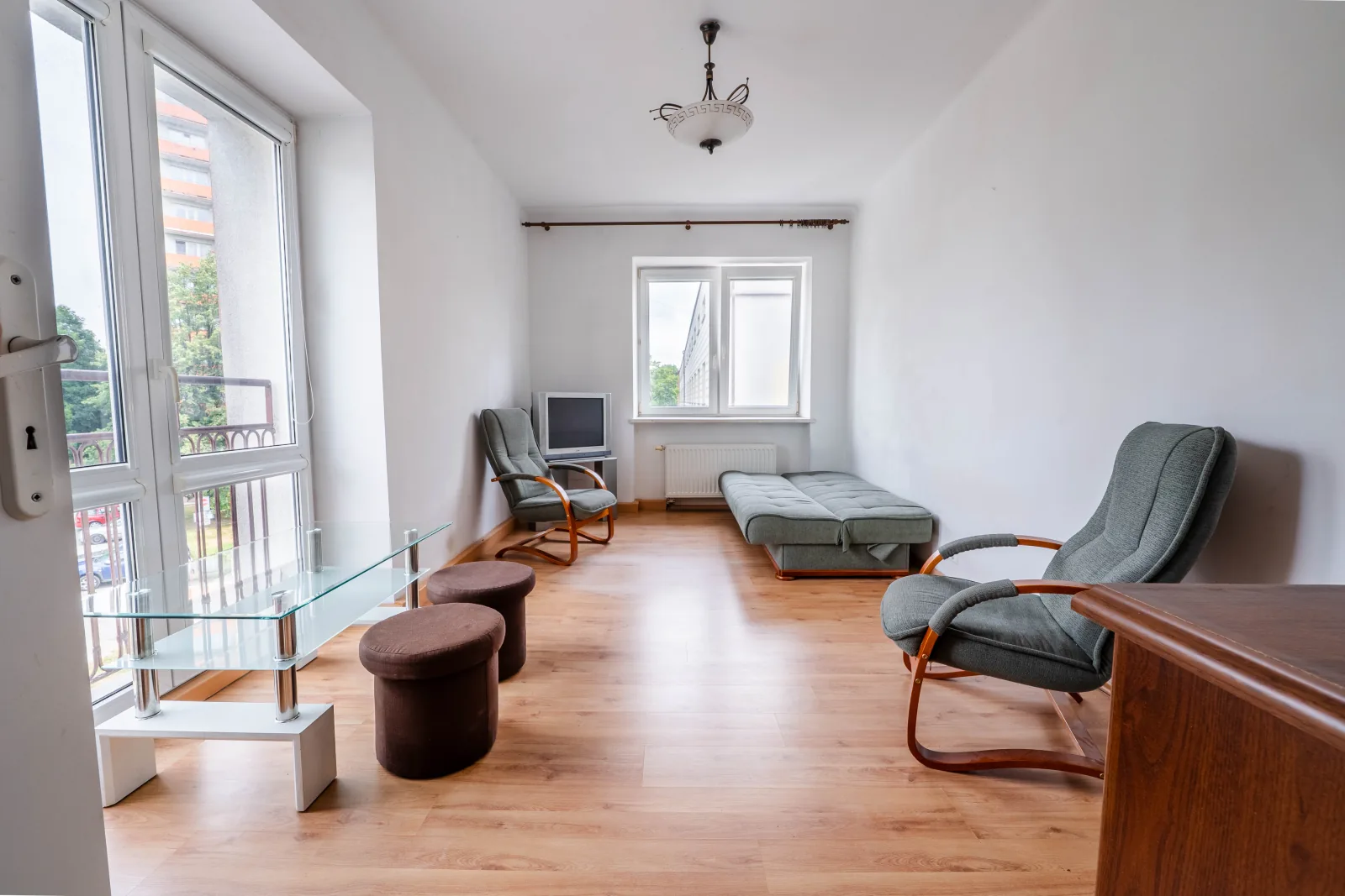 Pokój z wyjściem na balkon francuski, fotele i stolik