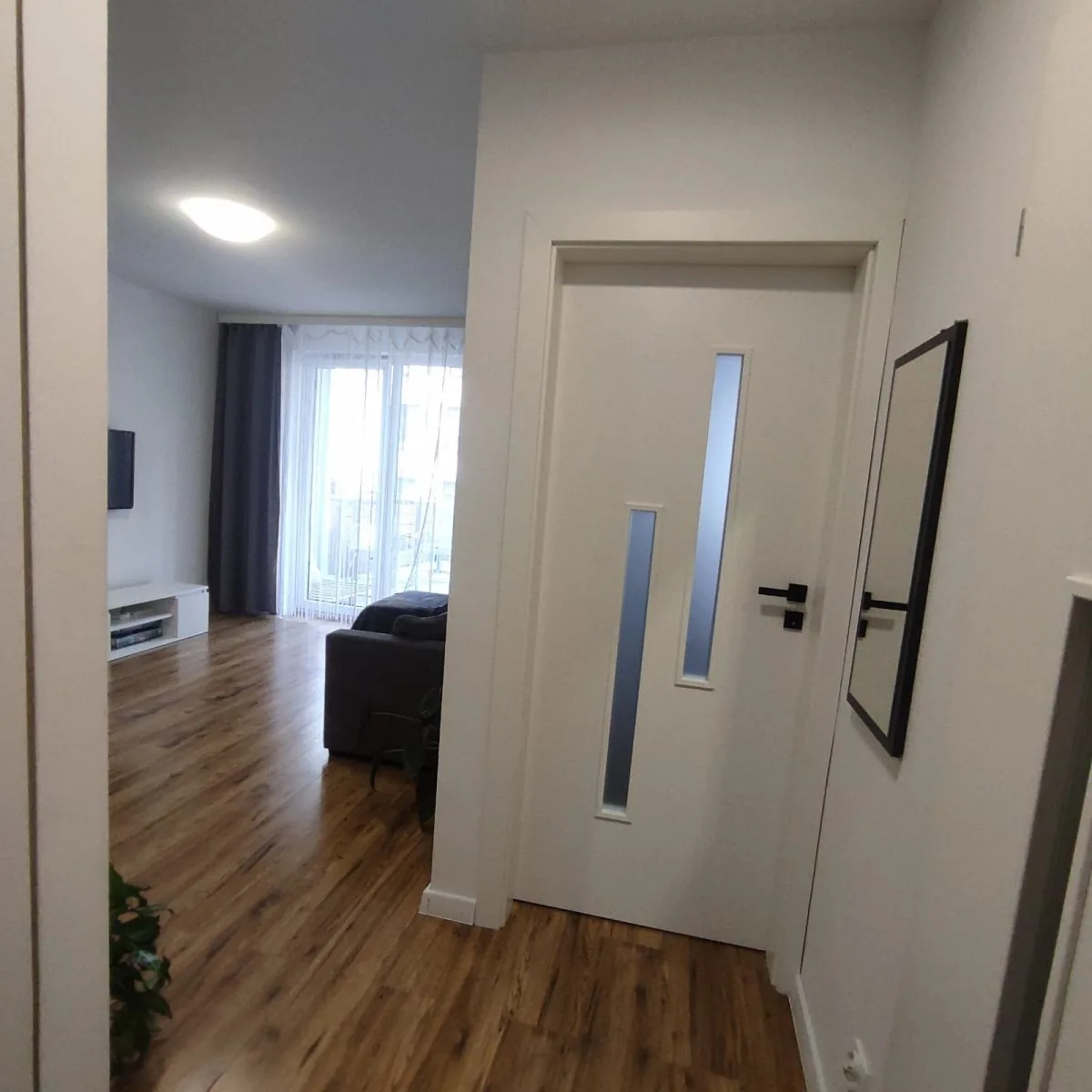 Przejście z przedpokoju do salonu, duże okno